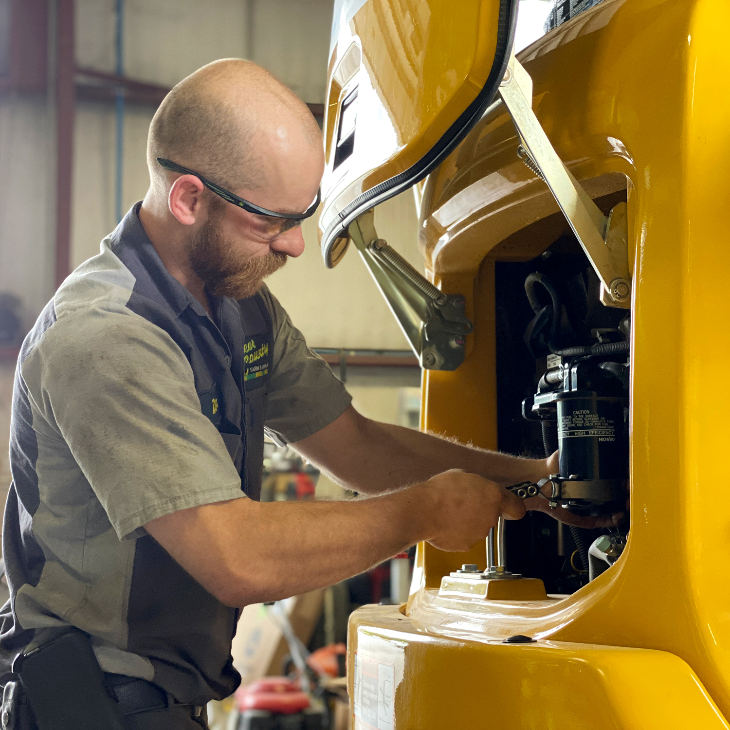 What we do - Technician working on a mini-excavator