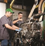 Two men giving service to a engine